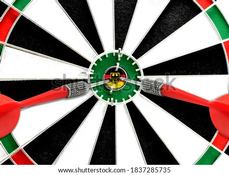 Close-up of a dart board with an imprinted flag of Germany in the center. The concept of achieving goals.