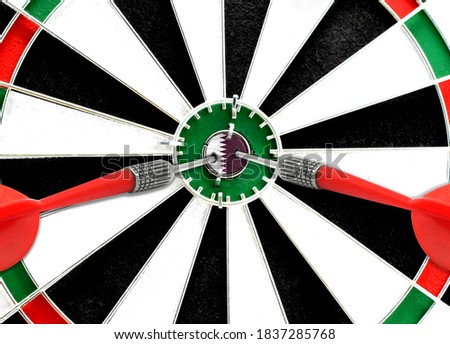 Close-up of a dart board with an imprinted flag of Qatar in the center. The concept of achieving goals.