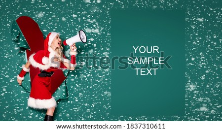 Beautiful blonde Santa girl in Christmas hat and costume shouting on megaphone.
