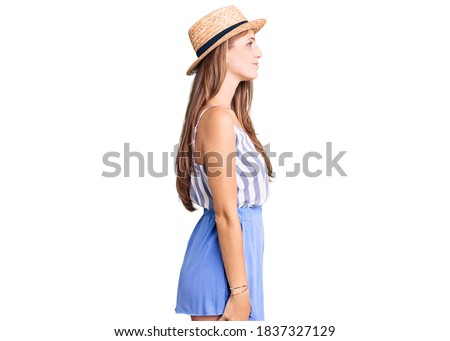 Young beautiful blonde woman wearing summer hat looking to side, relax profile pose with natural face and confident smile. 