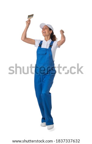 Female house painter with paint brush with raised arms isolated on white background full length studio portrait