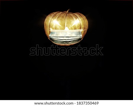 Halloween background. Black, dark and scary colors. There is a pumpkin illustration or cartoon, illuminated with candle light and wearing a medical mask complying the Covid-19 or Coronavirus measures.