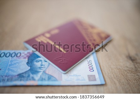 Picture of a Fifty Thousand Indonesian Rupees Bill partially inside a Swedish Passport