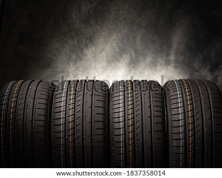 Tire stack background. Car tires on a black background. Four wheels. Royalty-Free Stock Photo #1837358014