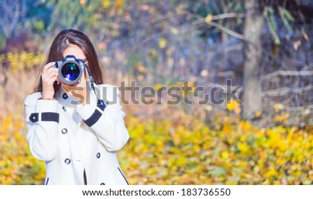 young attractive  woman using her camera to take photo outdoors at the park