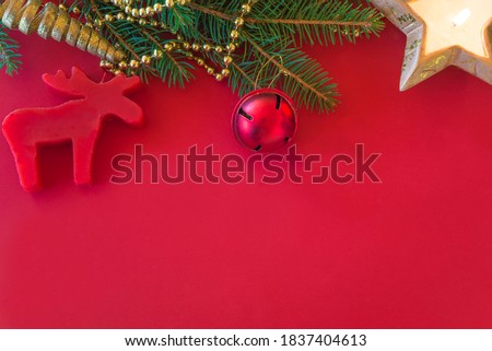 Template for christmas holiday greeting card. fir branch and christmas decoration on red background. Space for text, flat lay