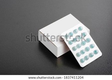 Pillbox with a loaf of tablets on dark background, editable mock-up series template ready for your design, faces selection path included.