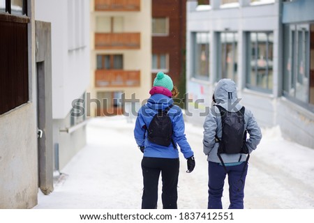 Tourists walking on street of mountain resort town in Switzerland, Europe. Winter vacation concept in Alps. Ski resort.