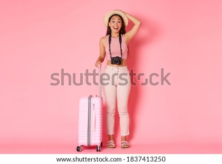 Tourism, summer vacation, holidays abroad concept. Full length of dreamy and amused asian girl traveller, tourist looking with amazement sideways, holding camera, want make pictures from journey