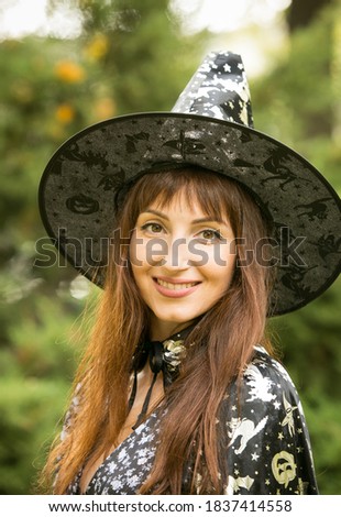 Halloween. Beautiful young woman in a festive mood at a Halloween picnic. Warm autumn October day. Emotion concept.
