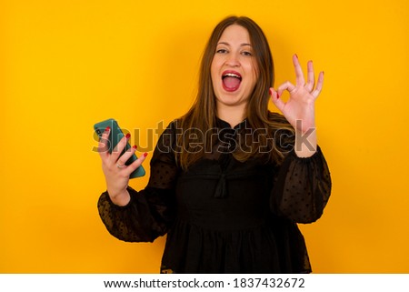 Portrait of a pretty happy Caucasian girl taking a selfie isolated over bright background