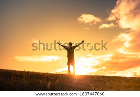 Young man with raised hands looking up to the sky. Finding your inner strength, happiness, and hope concept, Royalty-Free Stock Photo #1837447060