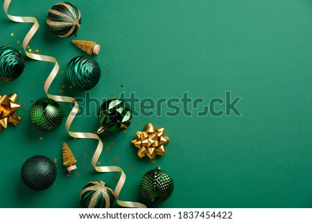 Christmas greeting card mockup. Elegant Xmas baubles and golden decorations on green background. Flat lay, top view. Royalty-Free Stock Photo #1837454422