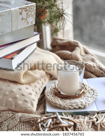 Winter home composition with lcandle, fir branches and cones, wrapped gift, hot coffee in a cup with star anise on white background.
Christmas morning holiday concept. Flat lay. Top view. 
