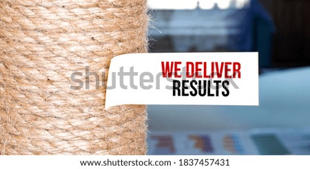 Torn brown paper on white surface with text WE DELIVER RESUTLS word.