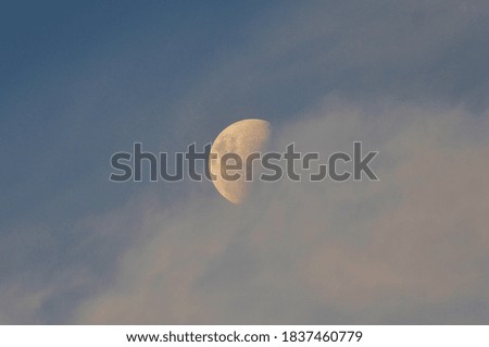 The crescent moon hiding behind the clouds