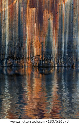 Landscape of mineral stained cliff and interesting reflections along the eroded sandstone shoreline of Lake Superior, Pictured Rocks National Lakeshore, Michigan’s Upper Peninsula, USA