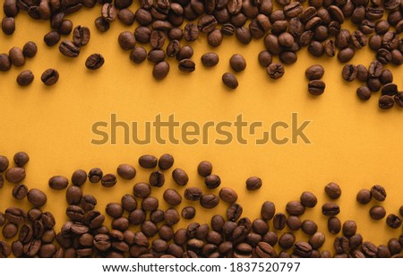 Coffee beans isolated on yellow background. Top view with copy space for text