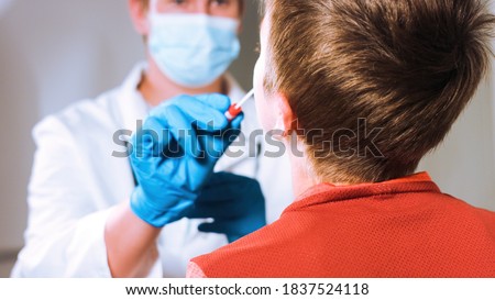 Doctor takes a cotton swab coronavirus test from child nose to analyse if postitve for covid-19. Royalty-Free Stock Photo #1837524118