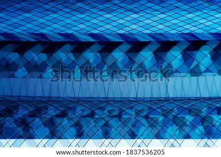 Double exposure photo of structural glazing. Abstract modern commerical architecture or office buiding. Pattern of business skyscrapers. Geometric background with polygonal structure in sky blue color