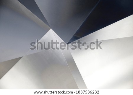 Angular metal panels. Steel sheets resembling abstract modern architecture exterior or interior detail. Industrial background in hi-tech style. Polygonal or polyhedron geometric pattern.