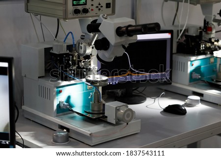Manual ultrasonic wire bonding machines at semiconductor factory. Selective focus. Royalty-Free Stock Photo #1837543111