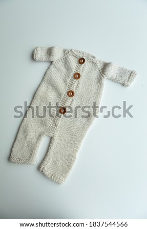 Hand-knitted newborn costume of various colors and types on a white background.