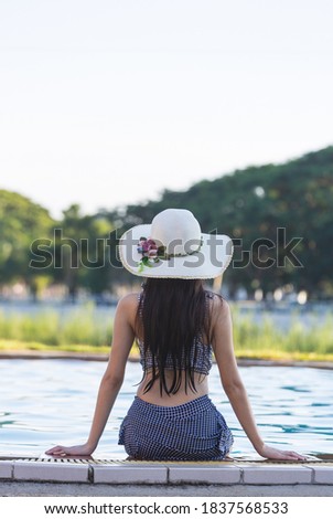 Portrait back fo a young asian girl relax smile leisure around outdoor swimming pool in holiday vacation travel trips concept