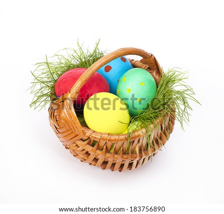 Easter eggs  with grass in wicker on white background