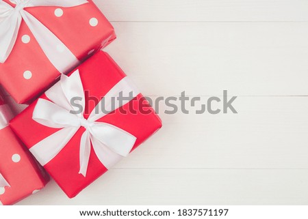 Red gift box on wooden table in Christmas day or holiday, present box on desk, for anniversary or birthday or celebration with copy space, celebrate and festive, top view, flat lay, nobody.