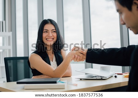 Business partners shaking hands together to start up small business in office room.
