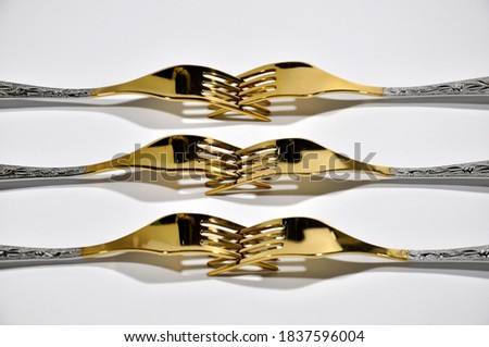 Golden forks on a white background.