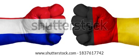 The concept of the struggle of peoples. Two hands are clenched into fists and are located opposite each other. Hands painted in the colors of the flags of the countries. France vs Germany