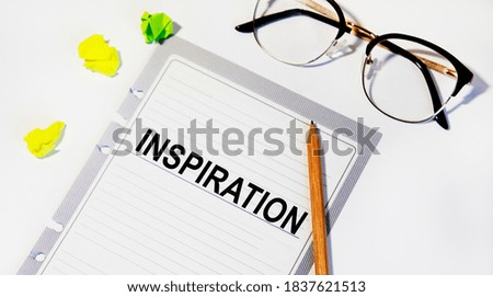 In the INSPIRATION diary, there are glasses, pencils and notes.