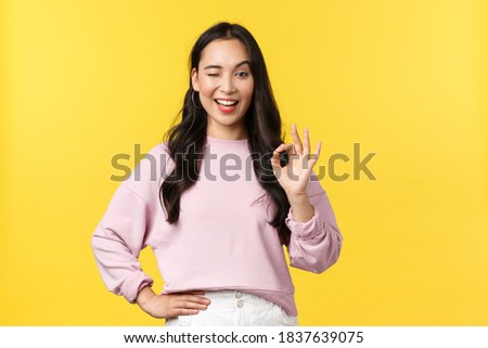People emotions, lifestyle and fashion concept. She got all under control. Satisfied and confident asian woman winking and smiling, encourage all good, show okay sign, recommend and guarantee quality