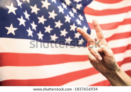 Man's hand showing victory over USA flag.United States elections 2020 concept.
