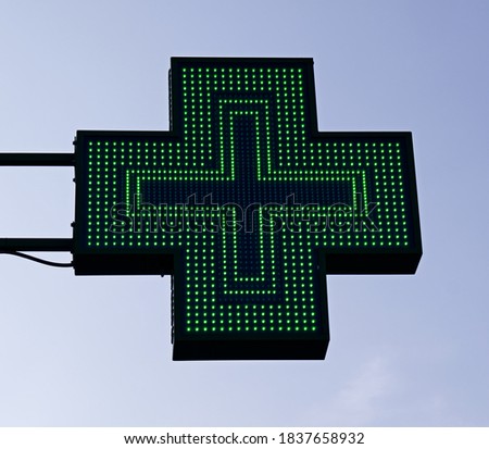 
Green cross pharmacy sign. European pharmacy store.