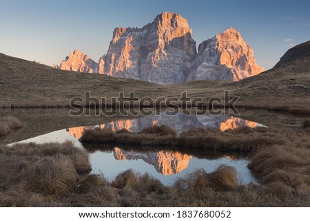 Seasonal autumnal scenery in highlands. Alpine landscape in Dolomite mountains, Southern Tyrol area, Italy. Popular travel destination in autumn. Aerial autumn sunrise scenery with yellow trees.