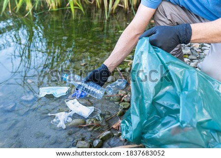 Close Up of Person Collecting Plastic From the River. Man Cleaning River of Plastics. Environment Concept. Royalty-Free Stock Photo #1837683052