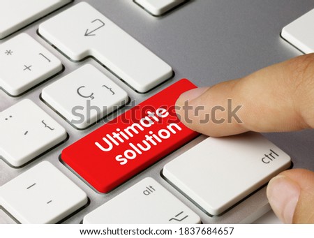 Ultimate solution Written on Red Key of Metallic Keyboard. Finger pressing key.