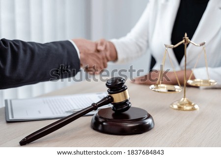 shake hand Professional male lawyers work at a law office There are scales, Scales of justice, judges gavel, and litigation documents. Concepts of law and justice.