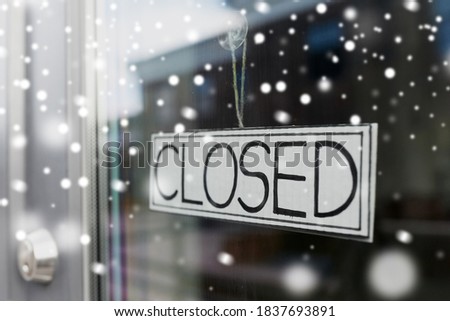 small business, pandemic and service concept - glass door of closed shop or office in winter over snow