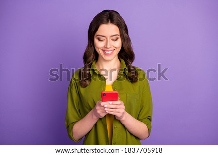 Portrait of positive cheerful girl use cellphone read social network information search comment feedback wear good look outfit isolated over purple color background