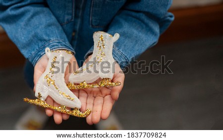 a Christmas tree toy in the form of skates is in the little children's hands. Christmas decoration. Christmas holidays