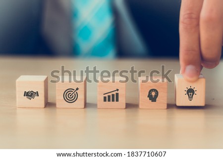 business man hand arranging wood block with icon strategy of business, action plan, goal, idea, strategic, partner with copy space