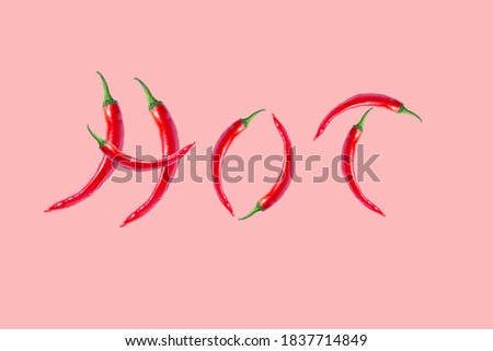 the word "hot" made from chili peppers. chili pepper isolated on a pastel pink background. word made from vegetables. advertising poster. background for website page.