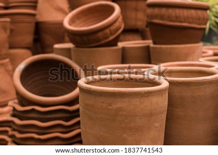 Stacks of various terracotta pots for plants for sale at a garden store. Royalty-Free Stock Photo #1837741543