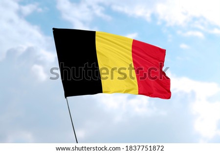 Flag of Belgium in front of blue sky