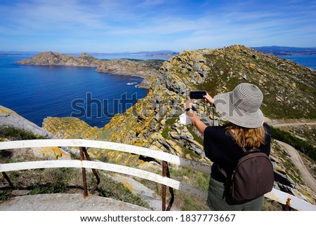 Woman taking photos in the Cies Islands Royalty-Free Stock Photo #1837773667