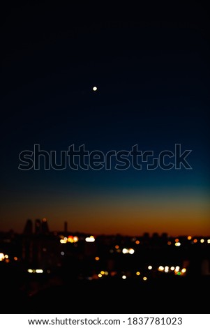 Blurred out of focus photo of city in dawn with star on the sky.